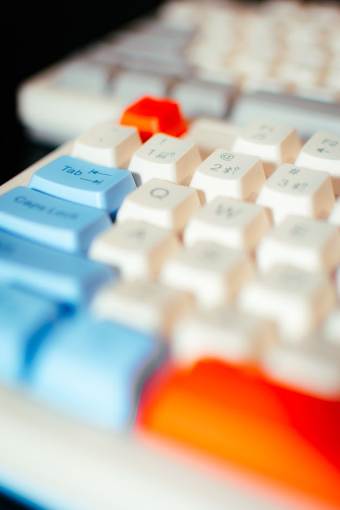 Services Vibrant close-up of a multicolored computer keyboard emphasizing blue, red, and white keys.